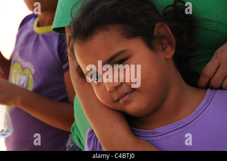 Una giovane ragazza, che si aggrappa a sua madre in Altare, Sonora, Messico, spera di migrare verso gli Stati Uniti. Foto Stock