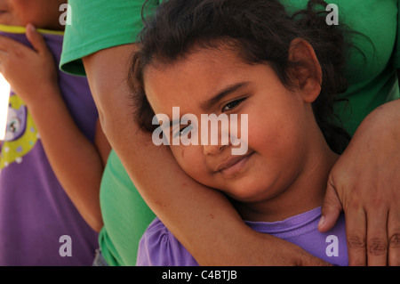 Una giovane ragazza, che si aggrappa a sua madre in Altare, Sonora, Messico, spera di migrare verso gli Stati Uniti. Foto Stock