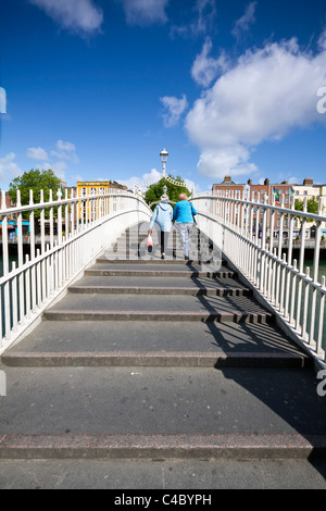 Dublino, Irlanda - 19 Maggio 2011: Uno dei maggiori punti di riferimento di Dublino Ha'penny Bridge sul fiume Liffey. Due senior pedestria Foto Stock