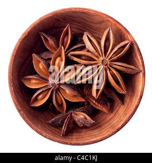 Anice stelle in una ciotola di legno isolato su bianco Foto Stock