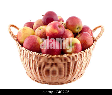 Cesto in Vimini pieno di mele isolato su bianco Foto Stock