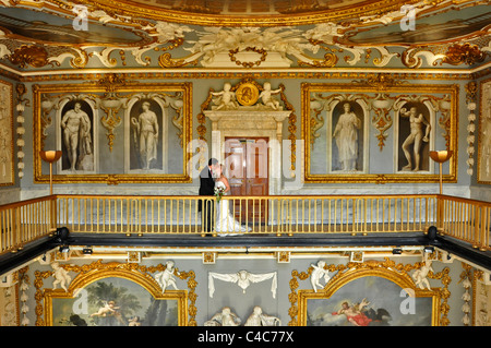 Sposa e lo Sposo baciare sul balcone in colorate altamente decorato stanza storica a Moor Park country club Foto Stock