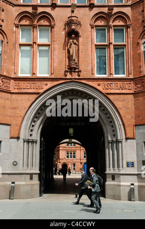 Persone che passano l'entrata al vecchio Prudential Assurance edificio in High Holborn Londra Inghilterra REGNO UNITO Foto Stock