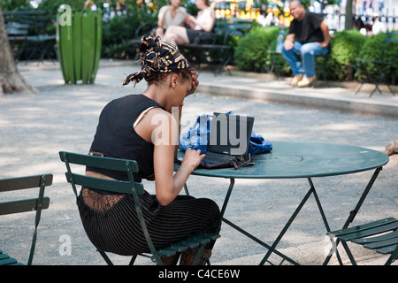 Gli utenti di computer di prendere vantaggio di esistenti di accesso internet wireless gratuito in Bryant Park di New York Foto Stock