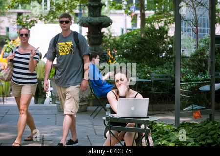 Gli utenti di computer di prendere vantaggio di esistenti di accesso internet wireless gratuito in Bryant Park di New York Foto Stock