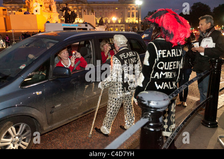 Perlacea re e regina di fronte a Buckingham Palace la notte prima del matrimonio regale del principe William e Kate Middleton Foto Stock