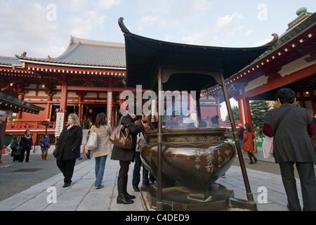 Le persone al calderone di incenso prendendo in salute-conferendo fumo e pregando in Senso-ji il Tempio Asakusa, Shitamachi, Tokyo, Giappone. Foto Stock