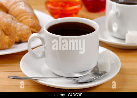 Tazza di caffè e croissant con marmellata sul tavolo di legno Foto Stock