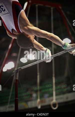 Ginnastica concorrenza: una del ginnasta esegue il suo alto routine bar Foto Stock