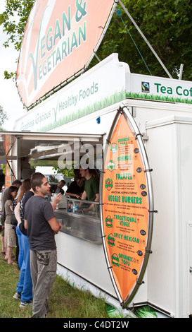 Persone che acquistano prodotti alimentari a un vegetariano il fast food stallo a un festival nel Regno Unito Foto Stock