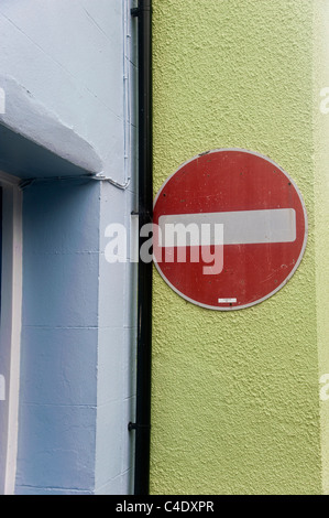 Un traffico no-entrata segno fissato ad un muro di casa, che è dipinto di verde. La parete adiacente è dipinto di blu pallido. Foto Stock