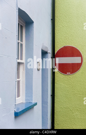 Un traffico no-entrata segno fissato ad un muro di casa, che è dipinto di verde. La parete adiacente è dipinto di blu pallido. Foto Stock