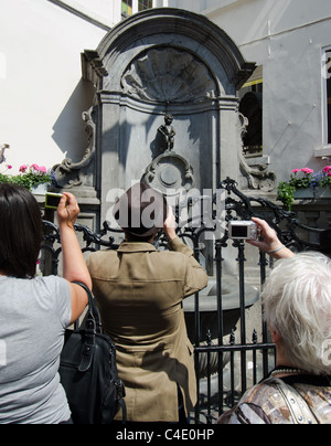 I turisti fotografare la statua Manneken Pis a Bruxelles Foto Stock
