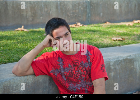 15-18 anno di età giovane Blackfoot nativo americano la meditazione orante pensieroso seduta da sola vista frontale dreaming park signor © Myrleen Pearson Foto Stock