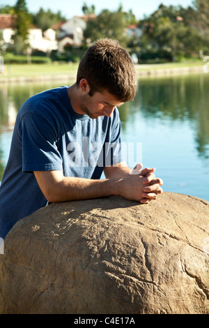 15-18 anni di età giovane meditazione orante e premurosa da sola nel parco. Signor © Myrleen Pearson Foto Stock