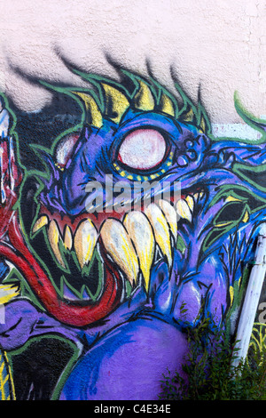 Un viola graffiti monster dipinta su una parete testurizzata Foto Stock