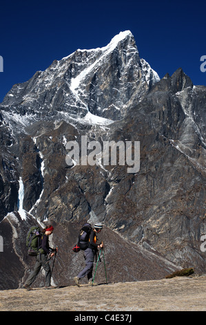 Due escursionisti femmina passano davanti a picco Taboche in Nepal Foto Stock