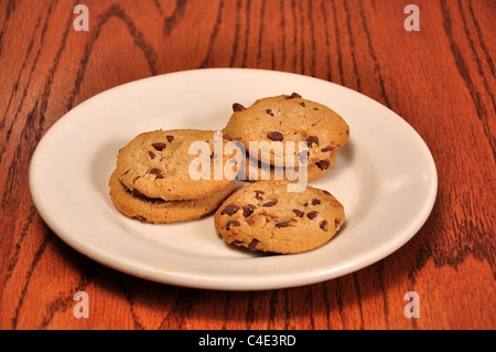 Cinque i cookie a sedersi su una piccola piastra sulla parte superiore di una tavola Foto Stock