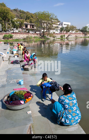 Donne che svolgono il servizio lavanderia. Lago Pichola. Udaipur. Il Rajasthan. India Foto Stock
