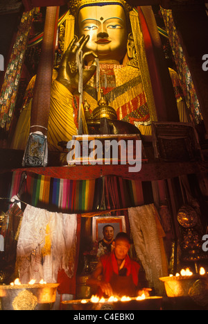 Monaco accendendo candele davanti al bronzo più grande statua del Buddha nel mondo, di Maitreya (Ciampa), il Buddha del futuro. Foto Stock