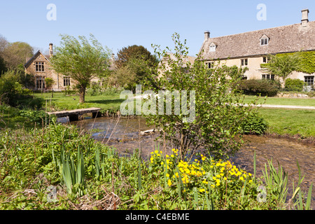 Antiche case coloniche accanto al fiume occhio nel villaggio Costwold di Upper Slaughter, Gloucestershire, England Regno Unito Foto Stock