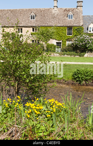 Una vecchia casa colonica accanto al fiume occhio nel villaggio Costwold di Upper Slaughter, Gloucestershire, England Regno Unito Foto Stock