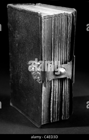 Nizza vecchia Bibbia con un vecchio blocco su uno sfondo nero. In bianco e nero. Foto Stock