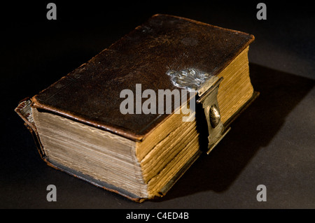 Nizza vecchia Bibbia con un vecchio blocco su uno sfondo nero. Foto Stock