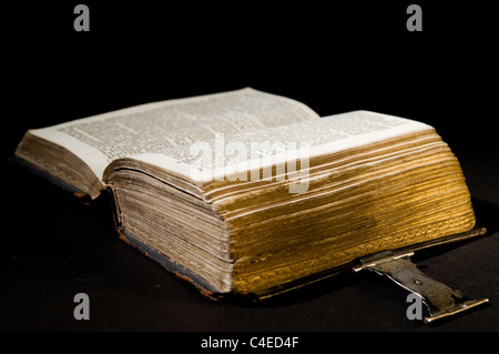Nizza vecchia Bibbia con un vecchio blocco su uno sfondo nero. Foto Stock