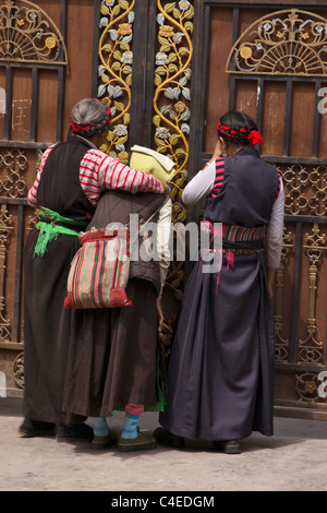 Donna che guarda attraverso una porta. Sade villaggio a nord di Julong, Sichuan, in Cina. Foto Stock