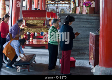 Persone scuotendo fortune sticks presso il Tempio Taoista di Xuen Miao Guan, Suzhou, Cina. Foto Stock