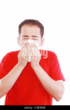 Giovane con un freddo soffia il naso sul tessuto Foto Stock