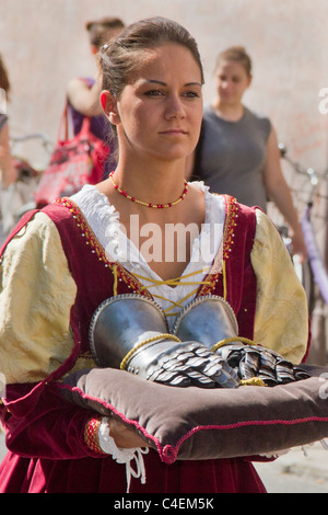 Ragazza in costume rinascimentale trasporta la corazza guanti in parata prima delle gare come parte del Palio.Ferrara,Italia Foto Stock