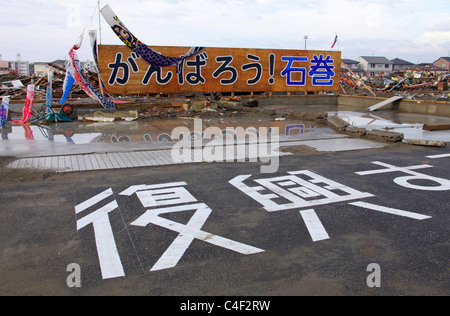 Un revival scritto slogan con Carp streamers per incoraggiare le persone in questa città devastata dal maremoto undicesimo marzo 2011 Foto Stock