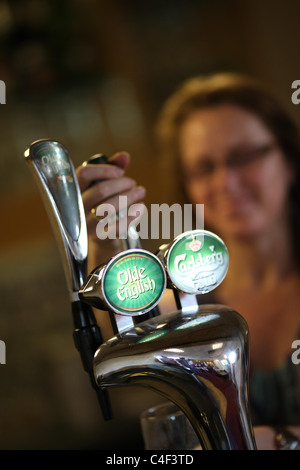 Una donna si versa la birra alla spina da una pompa. Foto di James Boardman Foto Stock