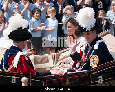 Il Duca e la Duchessa di Cambridge, wiving alla folla nel Castello di Windsor, Garter Day 2011, eccitati i bambini in background Foto Stock