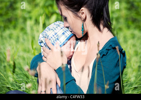 Giovane madre abbraccia il suo piccolo bimbo Foto Stock