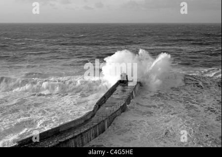 Una grande onda Atlantico si rompe sul molo Portreath, Cornwall Regno Unito. Foto Stock