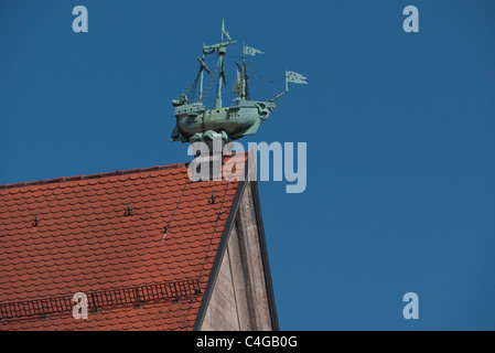 Vecchio weathervane di rame sotto forma di tre masted nave a vela del tipo noto come un argosy o ragusea rosso sul tetto di tegole. Foto Stock