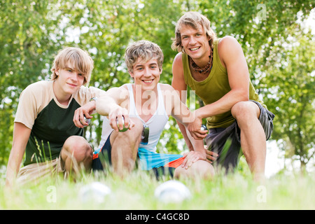 Un gruppo di giovani uomini la riproduzione di boule in un parco all'aperto in estate Foto Stock