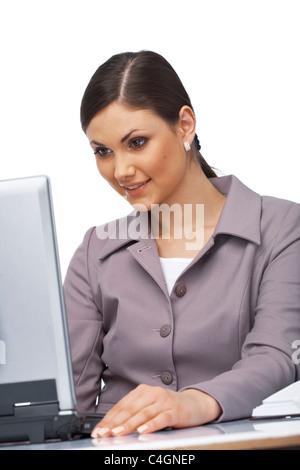 Azienda giovane donna seduta alla sua scrivania di blocco sorpreso sul suo computer portatile Foto Stock