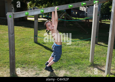 Due giovani ragazzi che giocano sulla palestra apparecchiatura nel parco. Foto Stock