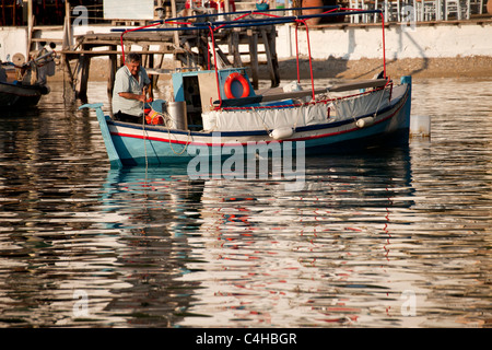 Impostazione di pescatori ancora sulla sua barca presso il piccolo porto di Agnontas, Skopelos Island, Sporadi settentrionali, Grecia Foto Stock