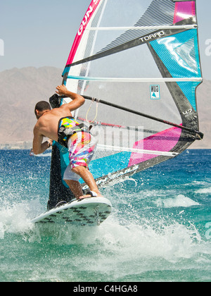 Un windsurf eseguendo acrobazie sul mar rosso presso il resort di Eilat in Israele. Foto Stock