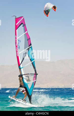 Un windsurf eseguendo acrobazie sul mar rosso presso il resort di Eilat in Israele. Foto Stock