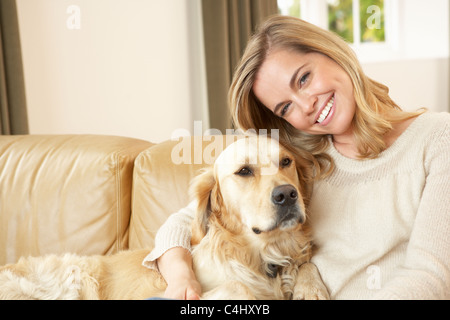 Giovane donna con il cane seduto sul divano Foto Stock