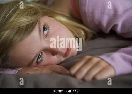 Premuto ragazza adolescente giacente in camera da letto Foto Stock