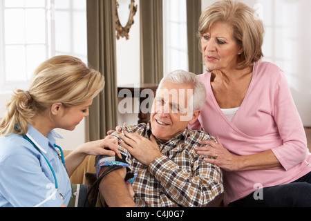 Salute visitatore prendere senior dell'uomo della pressione del sangue Foto Stock