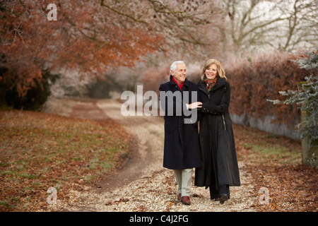 Coppia senior in inverno a piedi attraverso il pupazzo di neve il paesaggio Foto Stock