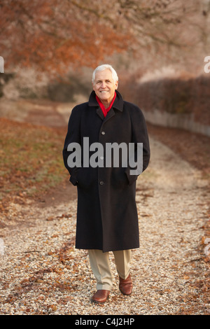 Senior uomo sulla Passeggiata invernale attraverso il pupazzo di neve il paesaggio Foto Stock